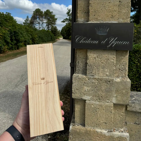 Château d'Yquem wooden wine case at estate entrance gate in Sauternes Bordeaux France showing premium dessert wine packaging