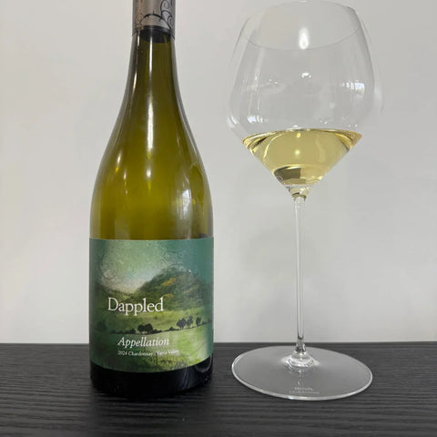 2024 Dappled Appellation Chardonnay white wine bottle from Yarra Valley with filled wine glass showing golden colour on dark wooden surface